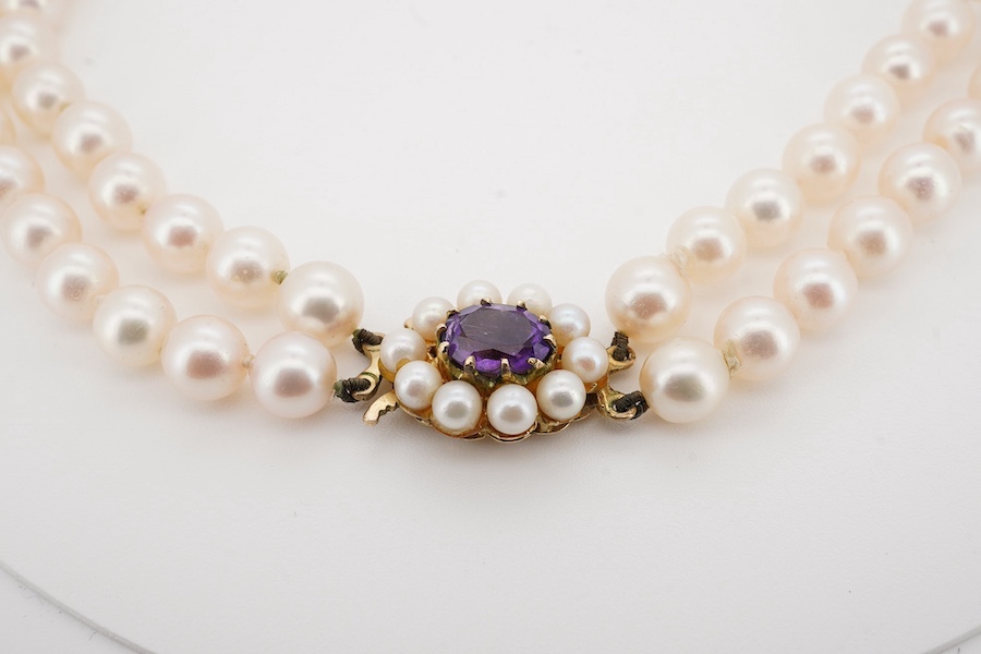 A modern twin strand cultured pearl necklace, with amethyst and cultured pearl cluster set 9ct gold clasp, 44cm. Condition - fair to good